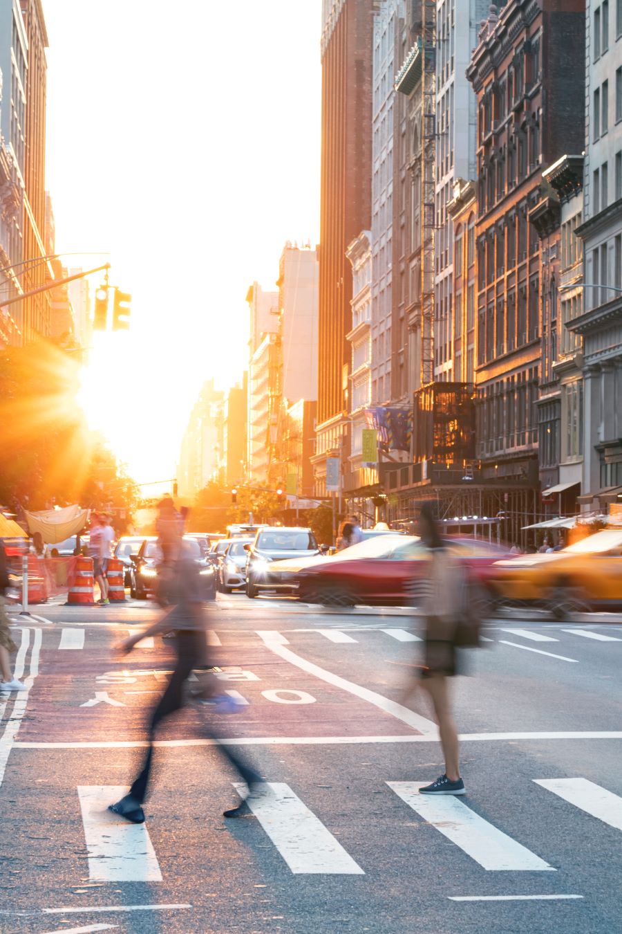 People in motion walking across a busy intersection on 5th Avenue in Midtown Manhattan, New York City
