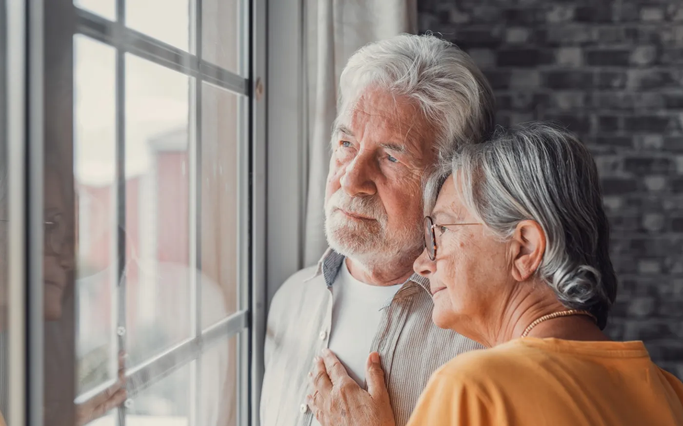 Old woman wife consoling and hugging sad husband