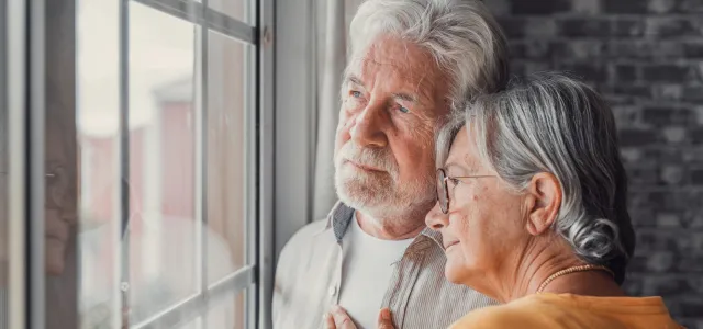 Old woman wife consoling and hugging sad husband